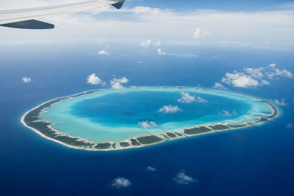 Hublot d&rsquo;avion au-dessus des atolls polynésiens, anneaux de corail turquoise sur l&rsquo;océan Pacifique